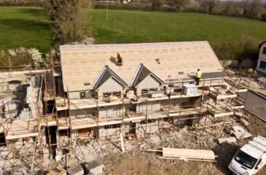 Aerial shot of a house under construction in Clonmel, Ireland. Workers on the roof.
