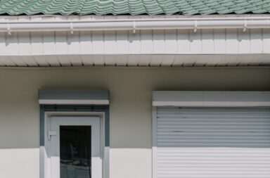 white wooden door and green house roof
